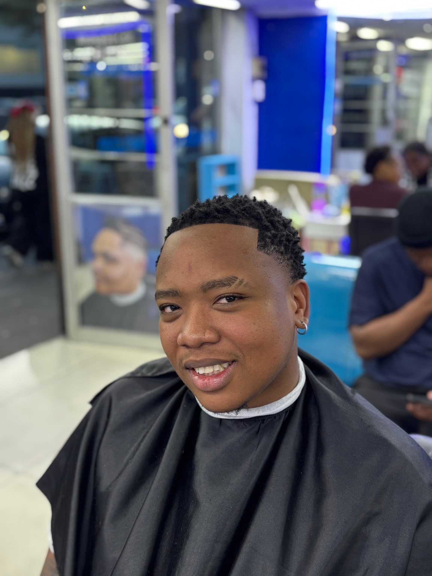 Smiling client showing a freshly finished textured haircut